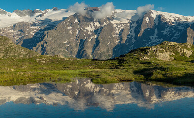 reflet des glaciers de la Meije sur un lac du plateau d'Emparis au refuge des Mouterres dans les Alpes en été