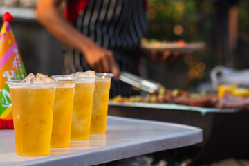 Beer drinks prepared for barbecue party among friends are served in plastic glasses because plastic glasses can be easily stored at end of party. Easy party idea by serving beer in plastic glasses.