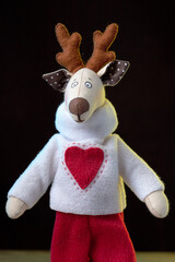 Handmade toy vintage Christmas deer on dark background