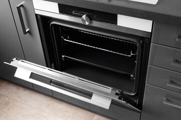 Obraz premium Built-in electric oven with open door in the kitchen.