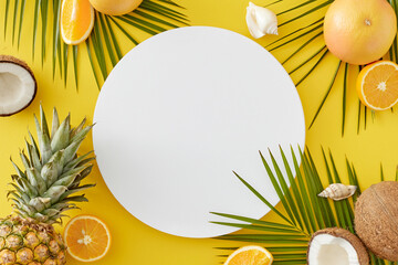 Fruit-focused summer theme. Top view composition of juicy citrus, pineapple, ripe coconuts, seashells, tropical leaves on yellow background with blank circle for ads or message