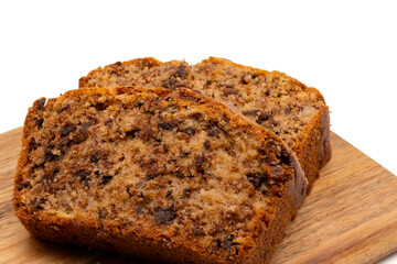 Slices of freshly baked homemade chocolate banana bread on a wooden board. Isolated on white background with copy space. Close-up view.