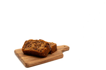 Slices of freshly baked homemade chocolate banana bread on a wooden board. Isolated on white background with copy space.