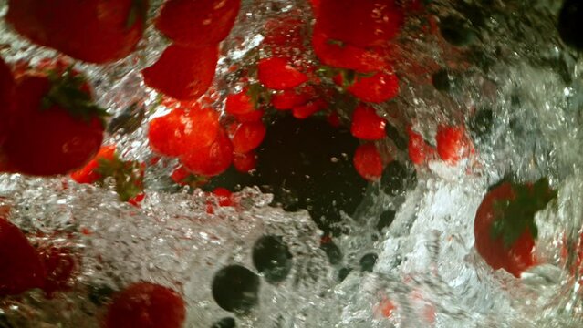 Super Slow Motion of Water Wave with Berries Fruit. Water Surf Wave Rotating Around and Creating Tunnel Shape. Filmed on high speed cinema camera, 1000 fps.