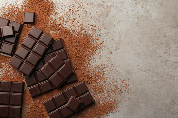 Delicious dark chocolate and cocoa powder on grey table, flat lay. Space for text