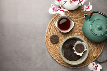 Flat lay composition with aromatic pu-erh tea on grey table. Space for text