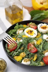 Delicious salad with pesto sauce and fork on white table, closeup