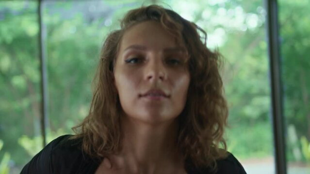 Caucasian female contemporary dancer moves smoothly gracefully looking at camera. Portrait of attractive woman performing modern choreography in dancehall