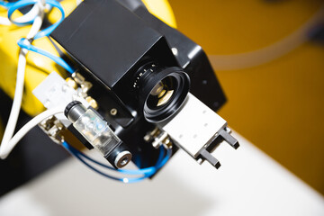 A close-up robotic arm equipped with a computer vision lens for processing video using artificial intelligence.