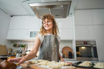 One happy young adult caucasian woman wear apron cook in the kitchen