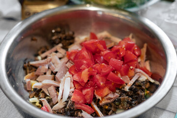 Cooking salad with meat, mushrooms and tomatoes