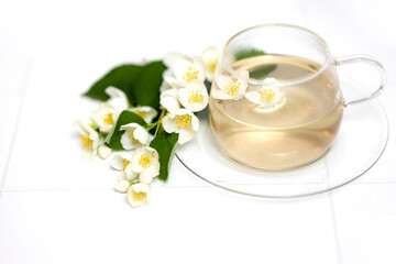 Fototapeta na wymiar Glass cup of tea with jasmine on the white background