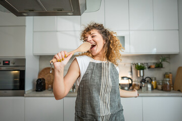 One happy young adult caucasian woman wear apron in the kitchen smile