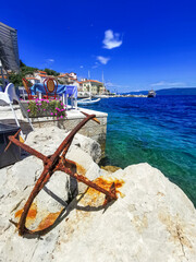 Kroatien - Insel Cres: Ansicht Ort Valun mit blauem Meer und rostigem Anker im Vordergrund