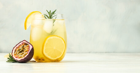 glass of Iced passion fruit soda with lemon and passion fruit half slice on a light background, refreshing drink or beverage with ice, place for text