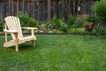 Natural pine armchair on green grass in the front garden