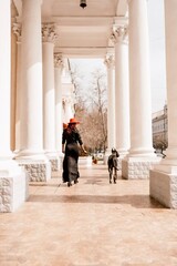 Fototapeta premium A photo of a woman and her Great Dane walking through a town, taking in the sights and sounds of the urban environment.
