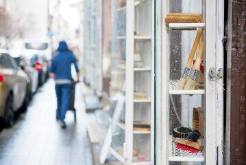 Obraz premium Brushes in a store window, person carrying trolley
