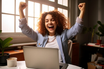 Joyful business woman freelancer entrepreneur smiling and rejoices in victory while sitting at desk and working at laptop after finishing project in home office. High quality photo