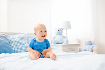 Little baby boy on white bed