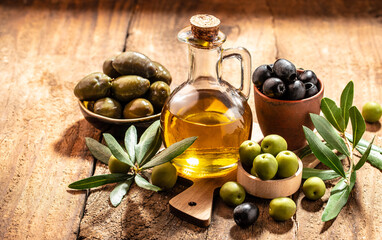 Olive oil and olive branch. extra virgin olive oil jars on a wooden background. place for text