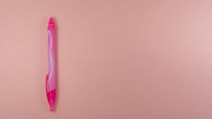 a pink black pen lies on a pink background. view from above