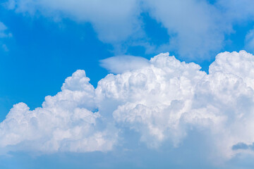 Naklejka na ściany i meble Large cumulus cloud in the blue sky on a sunny day. Background. Space for text.