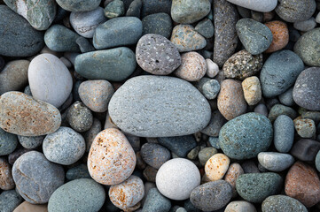 Fototapeta na wymiar Natural colorful pebbles. Rounded stones on the sea beach. Texture pattern for wallpaper. Harmony concept.