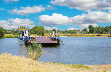 Afferden - Sambeek, Netherlands - Juine 9. 2023: Passenger, car and bike ferry crossing dutch river...