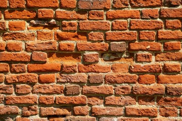 An old and heavily damaged brick wall as an architectural background