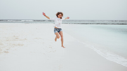 happy woman jumping on tropical beach