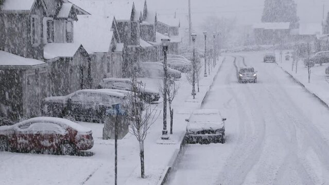 Person Driving Down Snowy Reidential Neighborhood