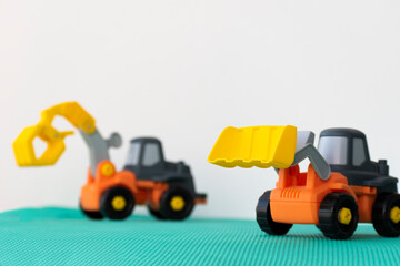 excavator toy on green hill, isolated on white background.