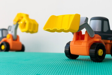 Fototapeta premium excavator toy on green hill, isolated on white background.