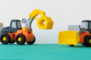 Obraz premium excavator toy on green hill, isolated on white background.