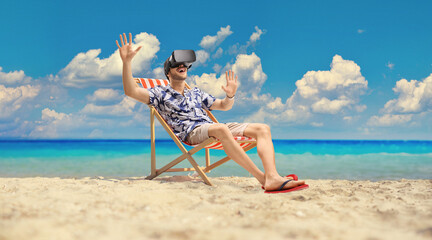 Man at the beach wearing a VR headset and sitting on a deck chair