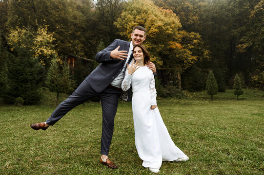 the groom has fun with the bride after the wedding ceremony in the autumn season. wedding season. tall groom and bride are happy.