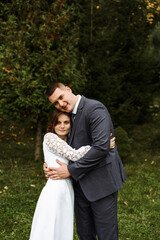 the young bride gently clings to the groom's chest. wedding day in autumn time.amazingly beautiful couple of newlyweds.