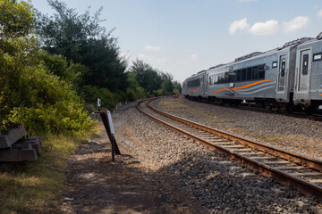 Obraz premium Domestic train pass the rail way when day time with blue sky.