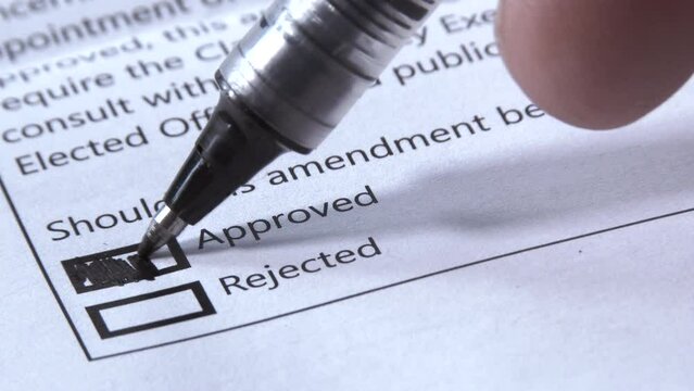 Close up on person approving an amendment on an official voter's ballot.