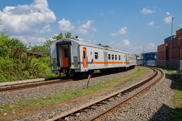 Fototapeta premium Domestic train pass the rail way when day time with blue sky.