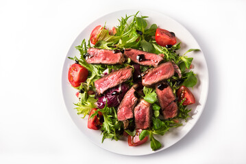 Pieces of beef with fresh lettuce and cherry tomatoes, dressed with olive oil and balsamic cream.
