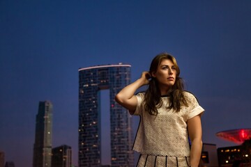 Fototapeta na wymiar Pensive middle-aged adult lady businesswoman at Dubai skyscraper night city, bored looking away. Confident jewish woman in summer vacation, resting lady. Leisure activity concept. Copy ad text space