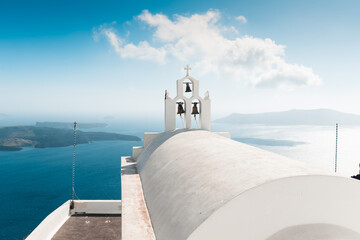 Fototapeta na wymiar magical and sun covered city of thira, ideal for vacation and travel during hot summer days, on the horizon the sea and beautiful roofs of houses, travel and relaxation in greece,white and blue 