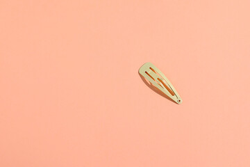Hair pin, hairstyle accessories on peach background