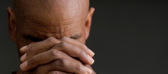man praying to god with hands together Caribbean man praying stock photo	