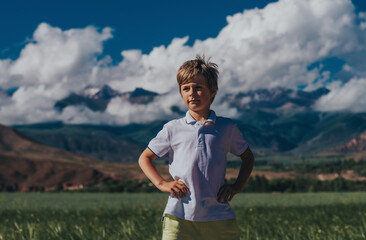 Obraz premium Portrait of boy on mountains background in summer