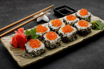 Sushi roll with red caviar, Philadelphia cheese, sesame and cucumber