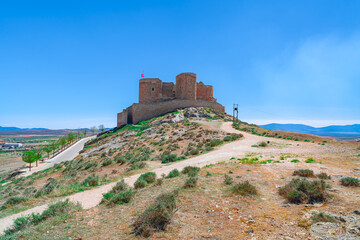 Castillo medieval en lo alto de una colina con caminos, desde Consuegra, Toledo, España.
