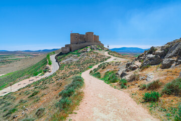 Fototapeta na wymiar Castillo medieval en lo alto de una colina con caminos, desde Consuegra, Toledo, España.